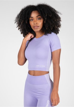 Lila sportieve crop top met korte mouwen, voorzien van een gestructureerd zijpaneel en het "GORILLA WEAR" logo op de voorkant. Gestyld met bijpassende leggings.