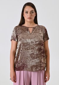 Top a maniche corte realizzato in tessuto metallico testurizzato nelle tonalità di marrone. Presenta un collo a chiave e una vestibilità ampia.