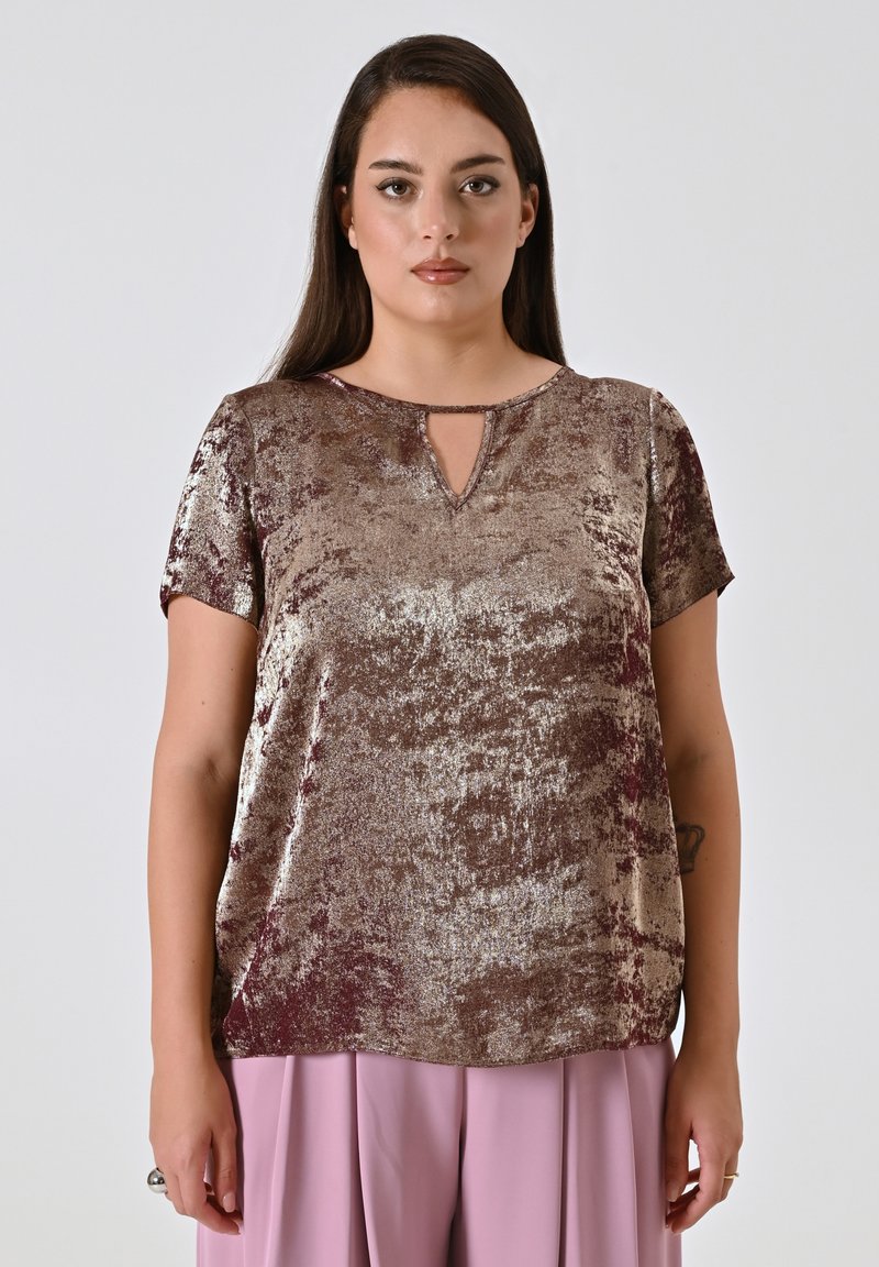 Top a maniche corte realizzato in tessuto metallico testurizzato nelle tonalità di marrone. Presenta un collo a chiave e una vestibilità ampia.