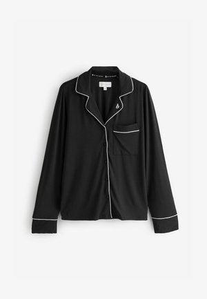Top pigiama nero a maniche lunghe con piping bianco, chiusura con bottoni e tasca sul lato sinistro. Realizzato in tessuto liscio e morbido.