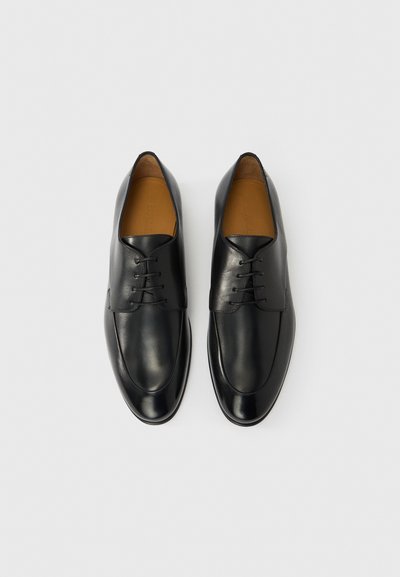 Μαύρα δερμάτινα παπούτσια με στρογγυλεμένη μύτη, λεία επιφάνεια, κλείσιμο με κορδόνια και καφέ εσωτερικό. Μινιμαλιστικός σχεδιασμός χωρίς ορατά σχέδια.