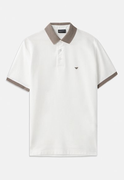 Bílá polo košile s hnědým pleteným límcem a akcenty na rukávech, s tříknoflíkovým zapínáním a malým logem nad levým hrudníkem.