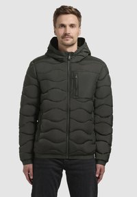 Dunkelgrüne Steppjacke mit Kapuze, gestepptem Wellenmuster, Vorderreißverschluss und Reißverschluss-Brusttasche. Glatte, leicht glänzende Textur.