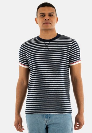 T-shirt rayé bleu marine et blanc avec un col rond, des manches courtes et des poignets accentués en rouge ; tissu doux en mélange de coton.