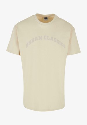 Helles beiges Kurzarm-T-Shirt aus weichem Stoff. Mit "URBAN CLASSICS" subtil in einem Bogen über der Brust bedruckt.