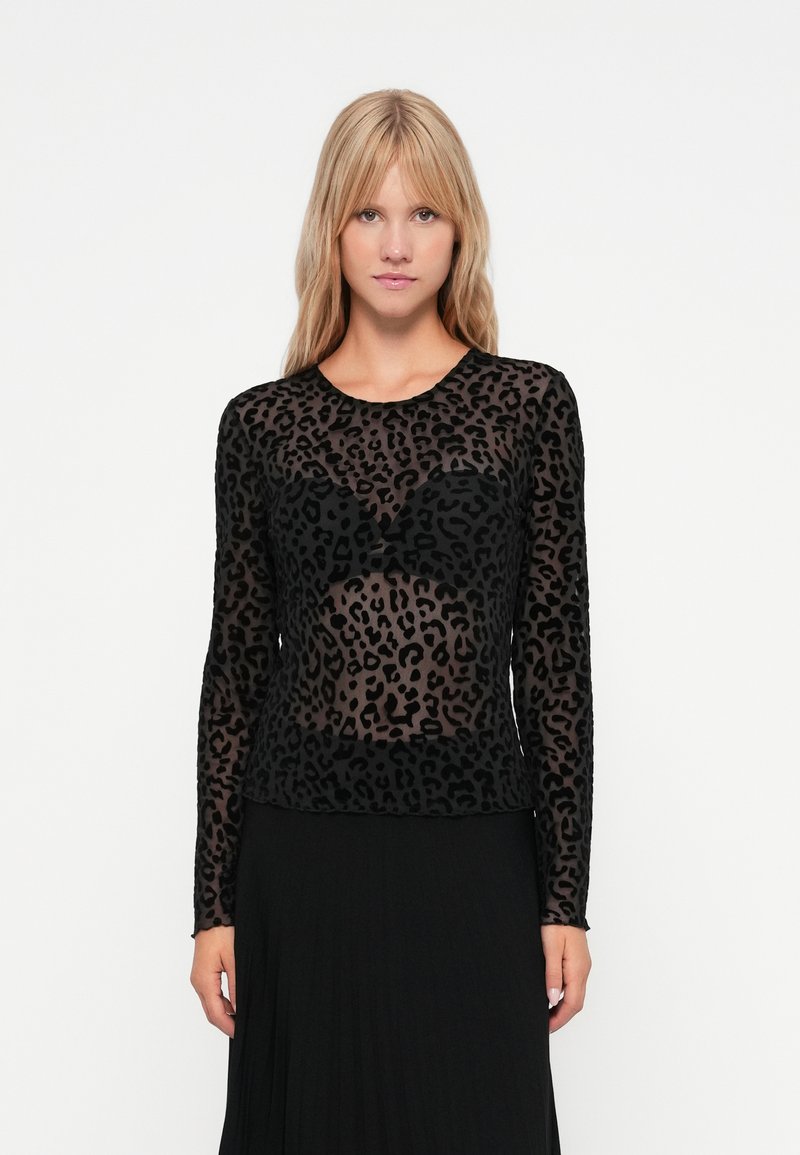 Cămașă neagră cu mânecă lungă, având un model leopard semi-transparent, cu guler rotund și un design ajustat. Textură moale cu un finisaj neted.