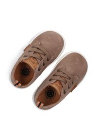 Braune Wildleder-Sneaker mit weißen Gummisohlen, ausgestattet mit beigen Schnürsenkeln, einem braunen Logo-Patch und einem gestreiften Akzent an der Ferse.