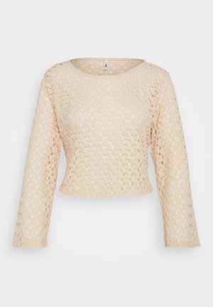 Beige kanten top met lange mouwen en een cropped ontwerp, voorzien van een ronde halslijn. Heeft een textuurpatroon overal.