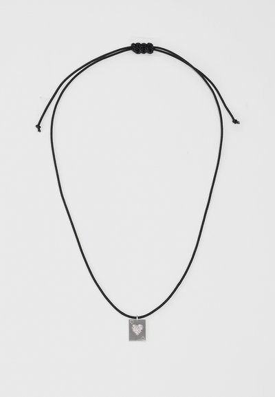 Collier en corde noire avec un nœud coulissant réglable, présentant un pendentif rectangulaire en argent avec un design de cœur et de petits accents en forme de cœur.