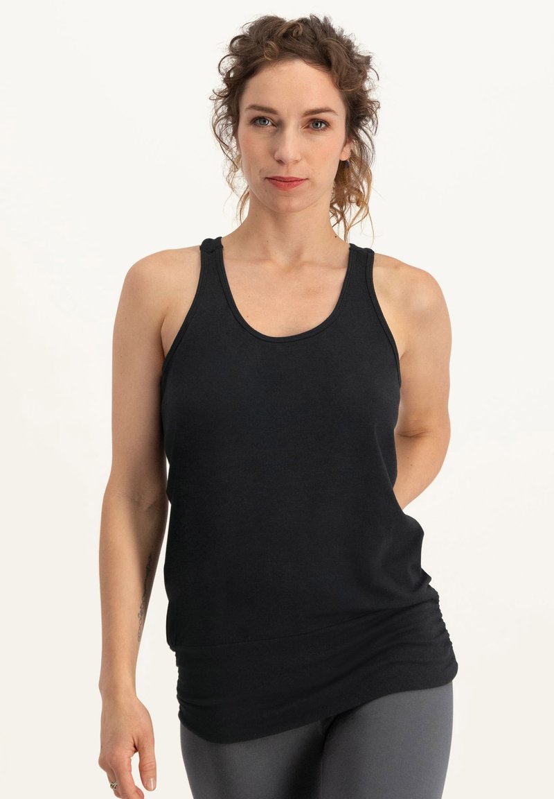 Svart linne i mjukt tyg med rund halsringning och tunna remmar. Har en rynkad textur vid midjan för en figursydd look.