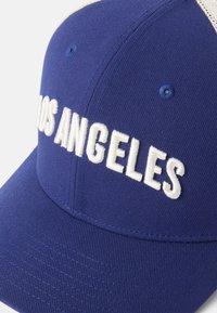 Niebieska czapka z zakrzywionym daszkiem, z wyhaftowanym napisem "LOS ANGELES" w kolorze białym. Wykonana z teksturowanej tkaniny, z siateczkowymi panelami z tyłu.