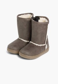 Brązowe botki za kostkę wykonane z teksturowanego materiału, z białymi plecionymi akcentami i miękkim futerkiem wewnątrz, na elastycznej gumowej podeszwie.