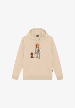 Sudadera beige con un bolsillo frontal, que presenta un gráfico de un oso con gafas de sol y un perro marrón. El material parece suave y con textura.