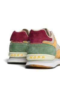 Sneaker multicolori con suede verde, bordeaux e senape, suola bianca e gialla, e marchio "HOFF" sul tallone.