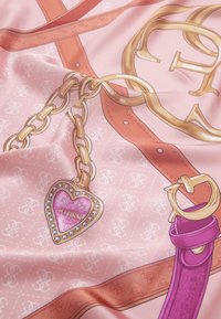Tessuto rosa con un motivo texturizzato presenta una catena dorata, un pendente a forma di cuore e una larga cinghia in un viola a contrasto.