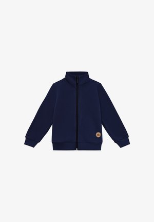 Granatowa kurtka na suwak z wysokim kołnierzem, wykonana z miękkiego materiału, z długimi rękawami i okrągłą naszywką z logo na dolnej lewej stronie.