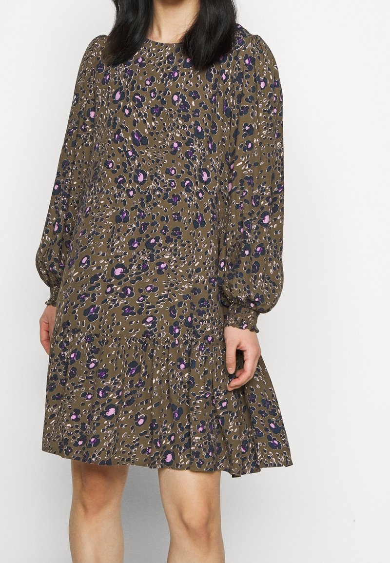Ruskea kuviollinen mekko, jossa on pitkät puffihihat, violetteja ja vaaleanpunaisia kukkakoristeita sekä kerroksellinen röyhelöhelma. Sileä kangas.