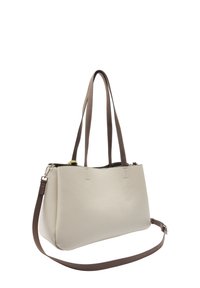 Beżowa skórzana torebka z podwójnymi uchwytami na górze oraz regulowanym brązowym paskiem na ramię, prezentowana na białym tle.