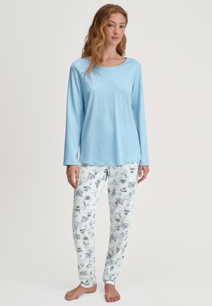 Hellblaues Langarmshirt mit rundem Ausschnitt, kombiniert mit weißen Hosen, die ein blaues Muster mit verschiedenen illustrierten Objekten aufweisen.