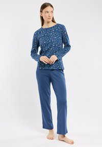 Ensemble de pyjama floral bleu comprenant un haut à manches longues avec un col rond et un pantalon assorti. Tissu doux avec une texture lisse.