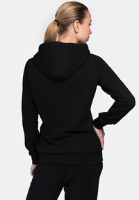 Black hooded sweatshirt made of soft fabric, featuring a kangaroo pocket, ribbed cuffs, and hem. Smooth texture, no visible patterns.