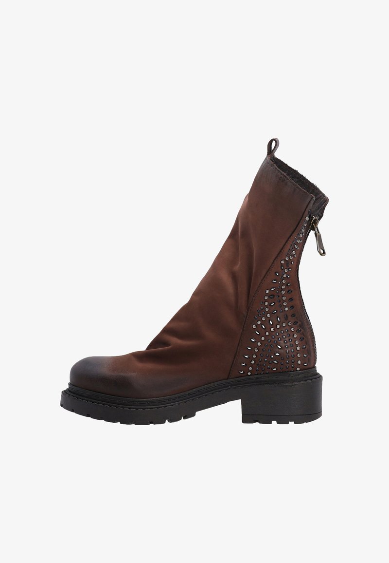Brązowy skórzany botek sięgający kostki o teksturowanym wykończeniu, ozdobione metalowymi ćwiekami po boku oraz masywną czarną podeszwą. Posiada zamek błyskawiczny.