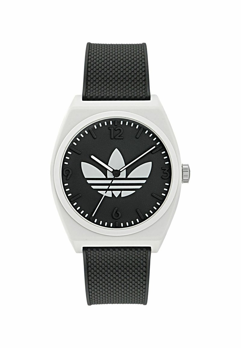 Montre noire avec un bracelet en caoutchouc noir texturé. Boîtier rond en argent, cadran noir arborant le logo Adidas, marquages horaires blancs et aiguilles blanches.