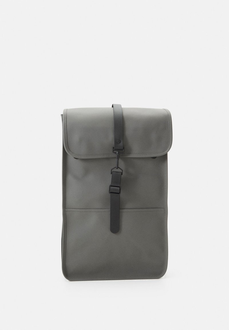 Zaino rettangolare grigio realizzato in materiale impermeabile, dotato di chiusura a pattina, cinturino nero con fibbia e una texture liscia e opaca.