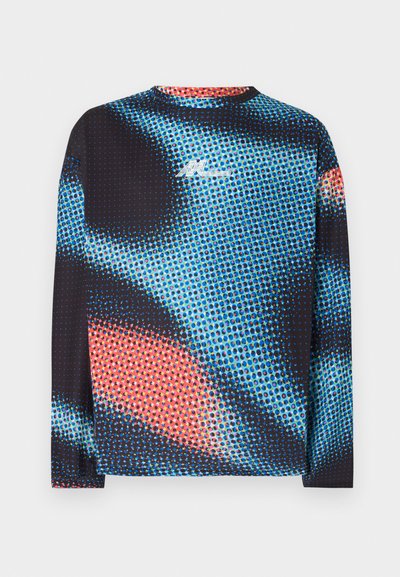 Chemise à manches longues avec un motif abstrait de points colorés en bleu, noir et rouge, arborant un petit logo blanc sur la poitrine.