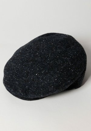 Uld flat cap i mørkeblå med et herringbone mønster. Rund form, blød tekstur og en let buet skygge. Minimalistisk design.