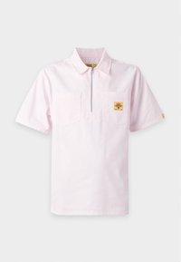 Ανοιχτό ροζ πουκάμισο με κοντά μανίκια και διακριτικές ρίγες, με κοντό φερμουάρ μπροστά, δύο τσέπες στο στήθος και ένα μικρό κίτρινο τετράγωνο μπαλώμα στην αριστερή τσέπη.