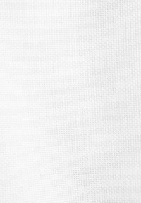Tissu blanc en maille gaufrée avec un motif en grille subtil, éclairé uniformément avec des ombres douces mettant en valeur la texture.