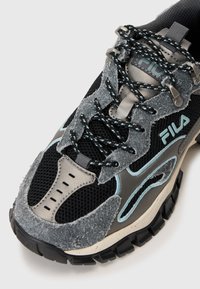 Sneaker neri e grigi con texture in rete e feltro, caratterizzati da accenti turchesi, suola in gomma spessa e design con lacci.