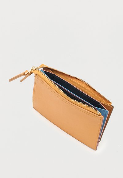 Μικρό ταμπά δερμάτινο πορτοφόλι με χρυστό φερμουάρ, που δείχνει πολλαπλές εσωτερικές θήκες σε μαύρο, μπλε και ροζ.