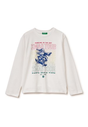 Witte longsleeve shirt met een grafisch ontwerp van een kerstman op een skateboard. De tekst omvat "DANCING IN THE SKY" en "XMASS TOUR" in levendige kleuren.
