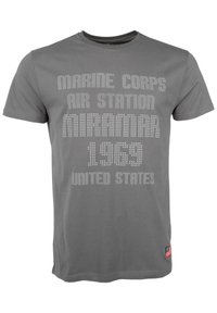 Grå bomullströja med vita strass-textgrafik: "MARINE CORPS AIR STATION MIRAMAR 1969 UNITED STATES." Inkluderar en flaggaccent.