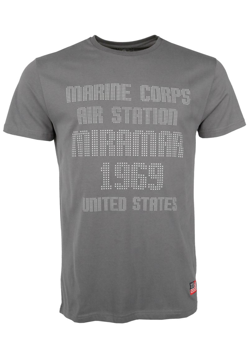 Grå bomullströja med vita strass-textgrafik: "MARINE CORPS AIR STATION MIRAMAR 1969 UNITED STATES." Inkluderar en flaggaccent.