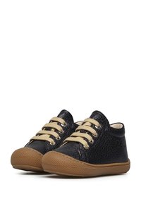 Černé boty z texturované kůže s béžovými tkaničkami, gumovou podrážkou a kulatou špičkou. Obsahují očka pro tkaničky a mají nízký střih.