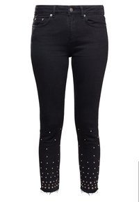 Svarta jeans med en figursydd design och hög midja, prydda med metalliska nitar längs fållen och fransar vid fållen.