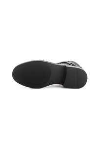 Suola di scarpa nera con superficie liscia e grip testurizzato. Presenta una forma arrotondata e un design minimalista, privo di motivi o dettagli distintivi.