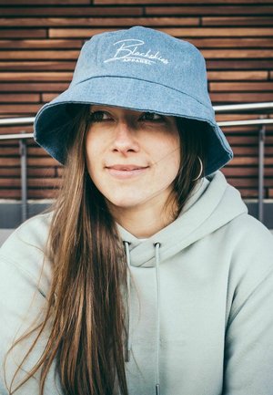 Denimist nööpiga müts laia äärisega, esipoolt kaunistab valge logo "Blackless Apparel". Pehme tekstuur, kantud helesinise kapuutsiga.