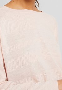 Hellrosa gestrickter Pullover mit einem strukturierten Muster aus horizontalen Streifen. Rundhalsausschnitt, lockere Passform und gerippte Bündchen.