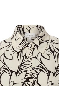 Blusa a maniche corte in tessuto crema, con motivo floreale nero. Presenta un colletto appuntito e una patta frontale con piccoli bottoni.