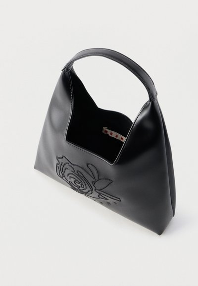 Μαύρη δερμάτινη τσάντα χειρός με κοντή λαβή, διακοσμημένη με κεντητό σχέδιο τριαντάφυλλου στο μπροστινό μέρος και ανοιχτό επάν ω μέρος με ορατή εσωτερική ετικέτα.