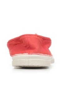 Scarpe slip-on in tela corallo con punta arrotondata e suola in gomma bianca; parte superiore testurizzata con dettagli cuciti lungo il bordo.