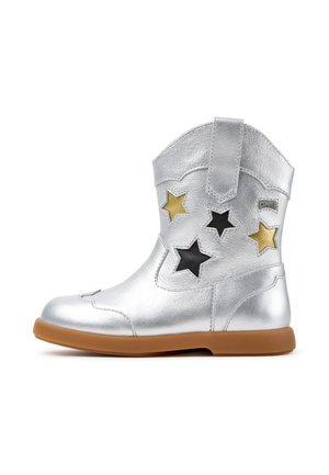 Silver ankle boot with brown sole, decorated with black and gold star cutouts on the side, and a pull tab at the top.