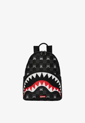 Zaino nero a scacchi con grafica di denti di squalo bianchi e rossi e piccoli motivi di orso e sole, dotato di maniglia superiore e doppia cerniera.