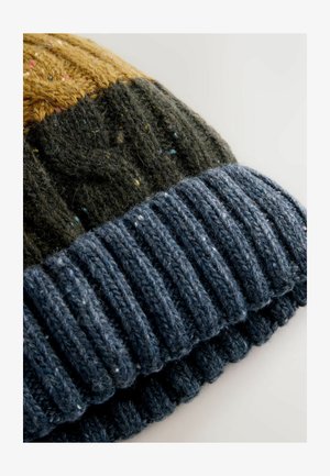 Strickmütze mit einem Muster, das dunkelgrüne, gelbe und marineblaue Abschnitte zeigt; gerippter marineblauer Saum; weiche Textur mit mehrfarbigen Sprenkeln.