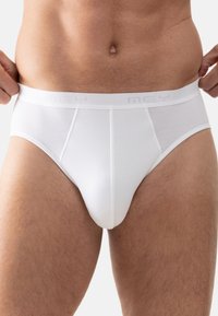 Hvite herreboxershorts lavet af blødt stof, med en glat talje med diskret branding, og en klassisk pasform med låg-liv design.