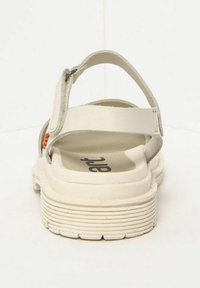 Sándalo blanco con una suela texturizada y correa de talón ajustable. Presenta una plantilla suave y acolchada, así como detalles de diseño minimalistas.